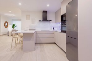 Una cocina moderna con una isla central, electrodomésticos de acero inoxidable y un diseño minimalista.
