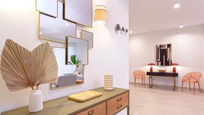 A modern hotel room with a wooden desk, a mirror, and a dining area with two chairs. - Genteel Home Teatro Gongora (Córdoba)
