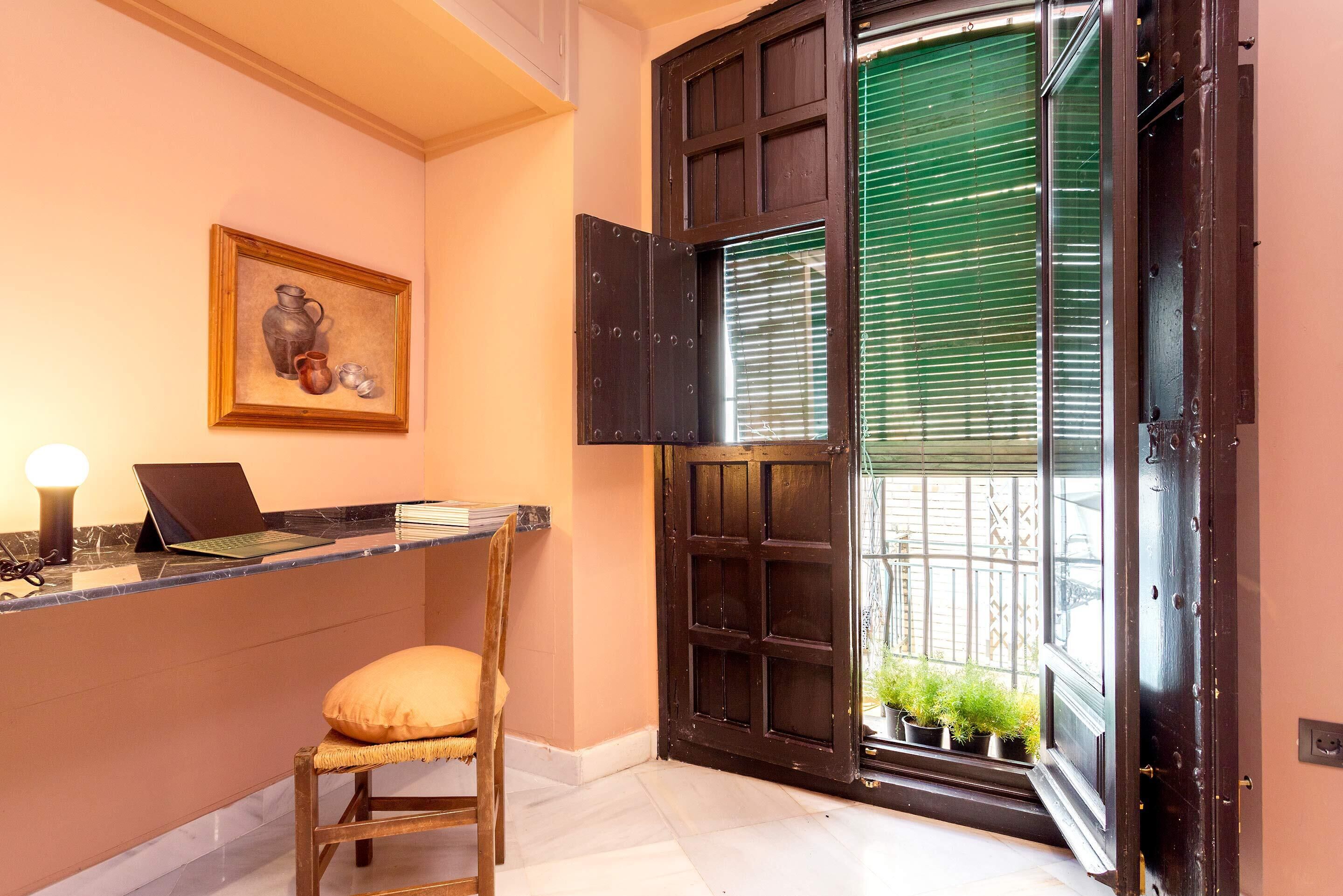 Una habitación con escritorio, silla y un cuadro en la pared.
