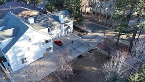 A residential area with a white house, a red car parked in the driveway, and a basketball court in front. - Munguia Summit Camp|Modern 2BR·Near to Snow Summit (Big Bear Lake)