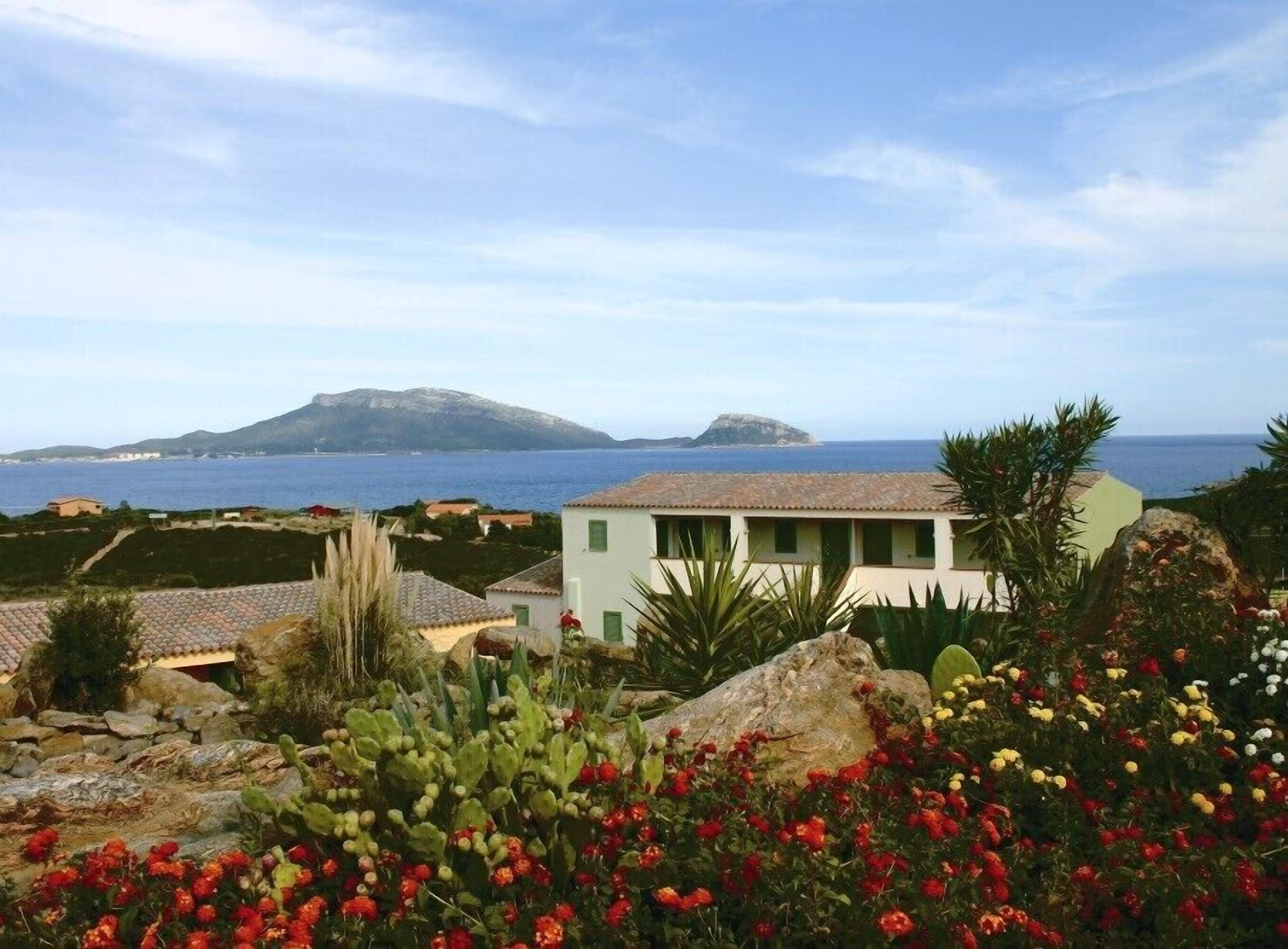 Una propiedad costera con vista al mar y una montaña al fondo.