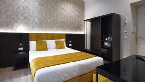 Et moderne hotelværelse med en stor seng, et skrivebord og et klædeskab.
