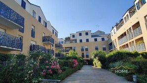 A residential building with balconies, a wooden pathway, and lush greenery. - 123home- Suite & spa XL (Montevrain)