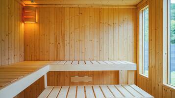 Eine Holzsauna mit Bänken und einer Wandleuchte.