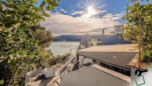 Un hotel moderno con vistas a un lago y montañas.