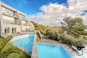 En säsongsöppen utomhuspool, parasoller och solstolar