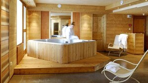 A wooden spa room with a hot tub, a lounge chair, and a reception area. - lesetoilesdelaplagne.com les montagnettes foot slopes (La Plagne-Tarentaise)