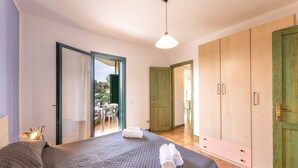 A bedroom with a bed, a wardrobe, and a balcony. - Apartments i Mirti Bianchi (Santa Teresa di Gallura)