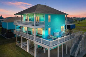 Ein zweigeschossiges Haus mit Balkon und überdachter Terrasse.