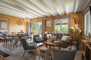 A cozy cabin interior with a wooden interior, a dining area, and a sofa. - Chalet Léonice - 8 guests - Jacuzzi & Sauna, Gérardmer (Gérardmer)
