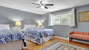 A bedroom with two beds, a ceiling fan, a window with curtains, and a patterned rug. - Comfort and Space near MSU (Lansing)