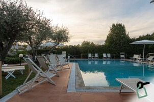 Una piscina al aire libre de temporada, sombrillas