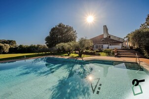 Una piscina al aire libre de temporada, sombrillas