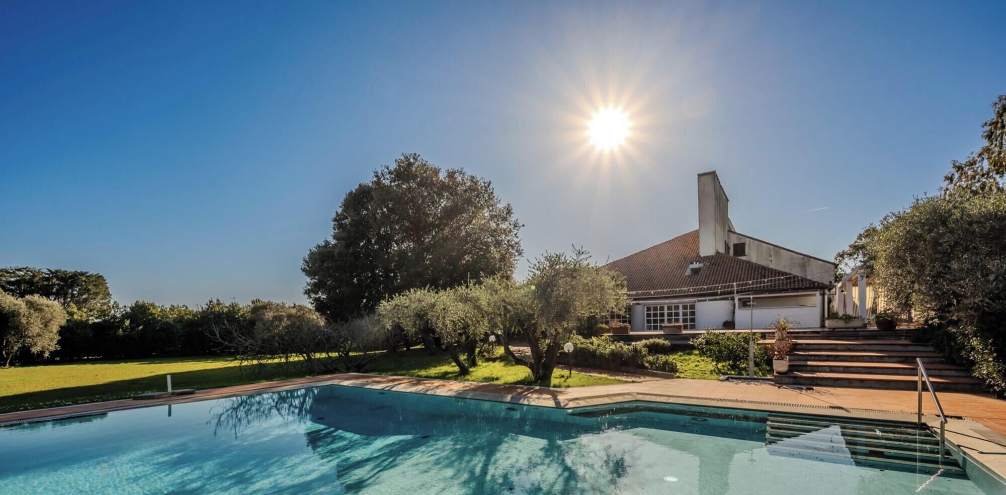 A swimming pool with a house in the background.