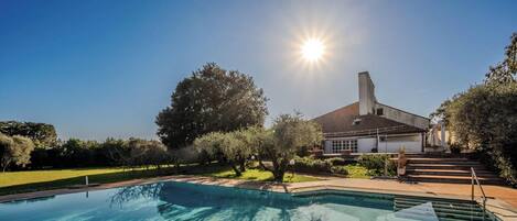 A swimming pool with a house in the background.