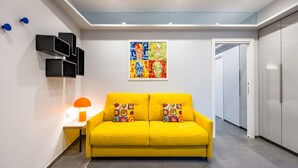 Un canapé jaune vif agrémenté de coussins colorés, une lampe moderne et un tableau abstrait aux couleurs éclatantes qui orne le mur.