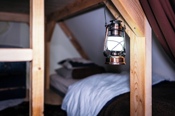 A wooden loft bedroom with a metal lantern hanging above a bed. - Cabane de la Saône by Lyon Country House (Caluire-et-Cuire)
