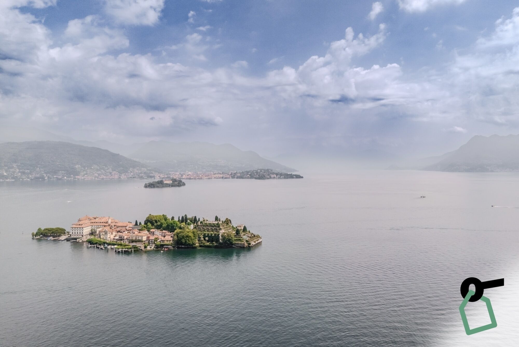 Un lago sereno con una pequeña isla que presenta edificios históricos y abundante vegetación.