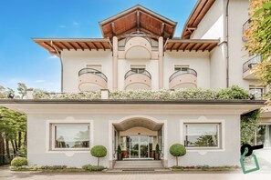 A modern building with a central entrance, multiple balconies, and a covered upper level. - Hotiday Room Collection - Stresa (Stresa)