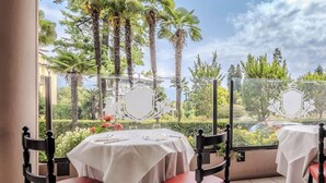 A dining area with two tables, each with a white tablecloth, and red upholstered chairs. - Hotiday Room Collection - Stresa (Stresa)
