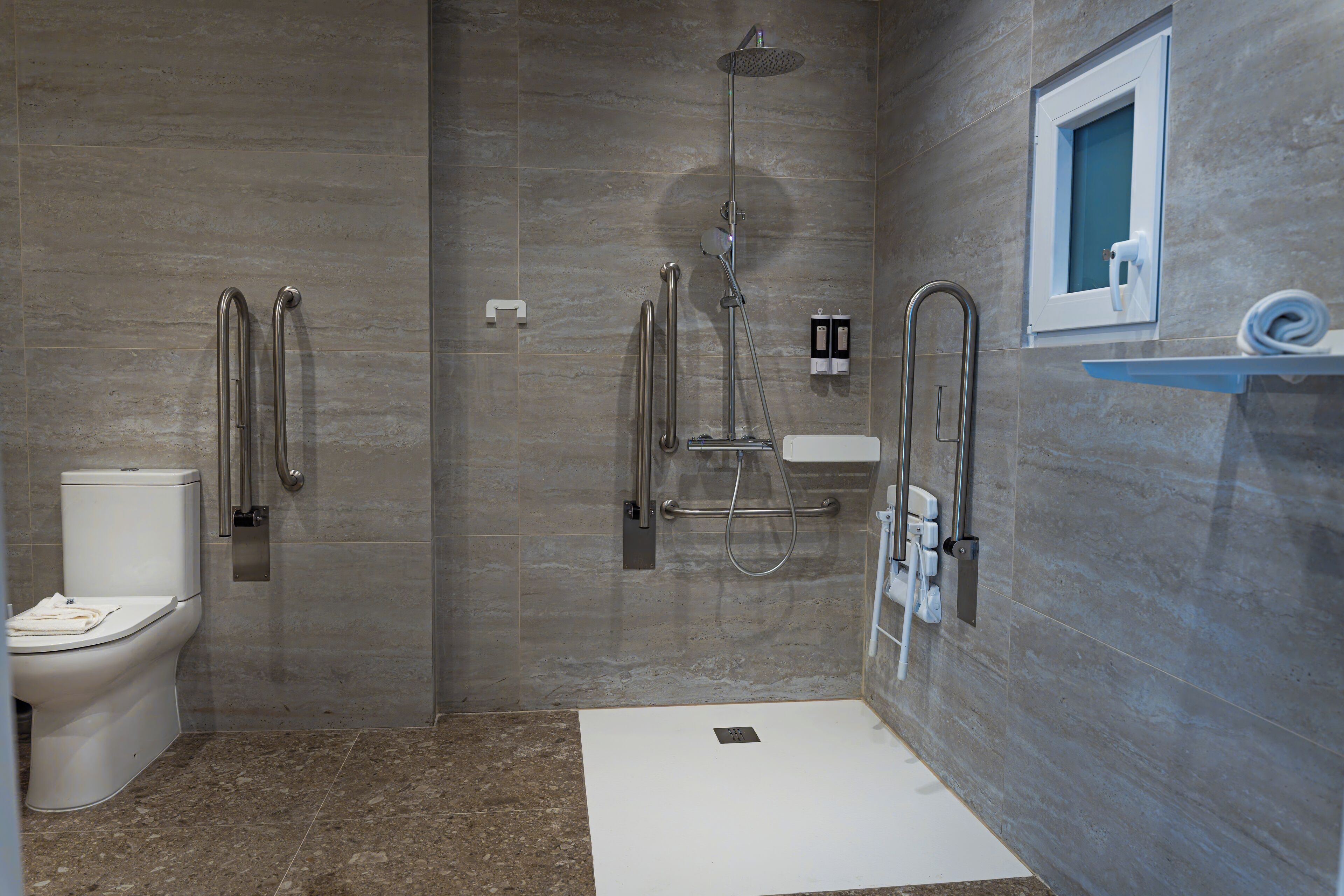 A modern bathroom with a shower, toilet, and sink.