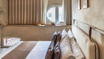 Habitación de hotel con una cama grande, una ventana con cortinas, una bandeja con alimentos para el desayuno y vistas al exterior.