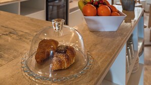 Een keuken met houten balken, een aanrecht met gebak en een fruitschaal.