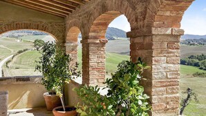 A stone archway with a view of a rural landscape. - AMORE RENTALS - Villa Valle with Pool, Garden, Ideal for Weddings (Sarteano)