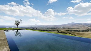 A swimming pool with a clear view of a tree and distant hills. - AMORE RENTALS - Villa Valle with Pool, Garden, Ideal for Weddings (Sarteano)