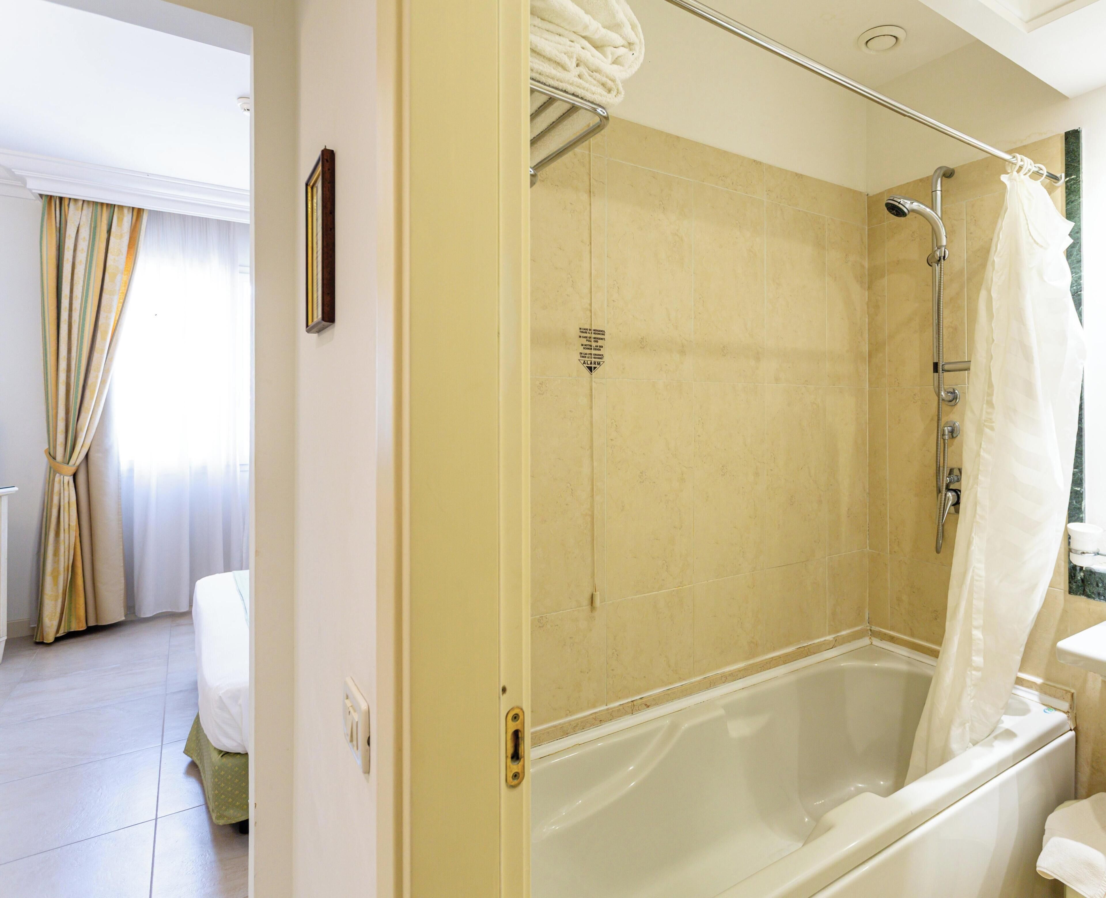 Un baño con bañera, ducha e inodoro.