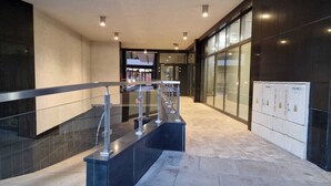 A modern interior with a glass partition, metal railings, and a tiled floor. - 1-bedroom in city center | balcony | close to the Main Square and Jewish Quarter (Kraków)