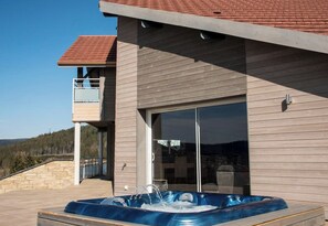 A modern building with a hot tub, a balcony, and a view of the mountains. - Chalet Horizon, 11-guest chalet in Gérardmer – Sauna, Jacuzzi (Gérardmer)