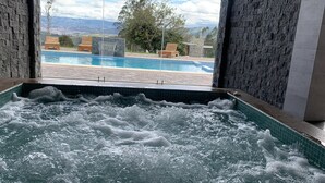 Un jacuzzi con vistas a una piscina y montañas.