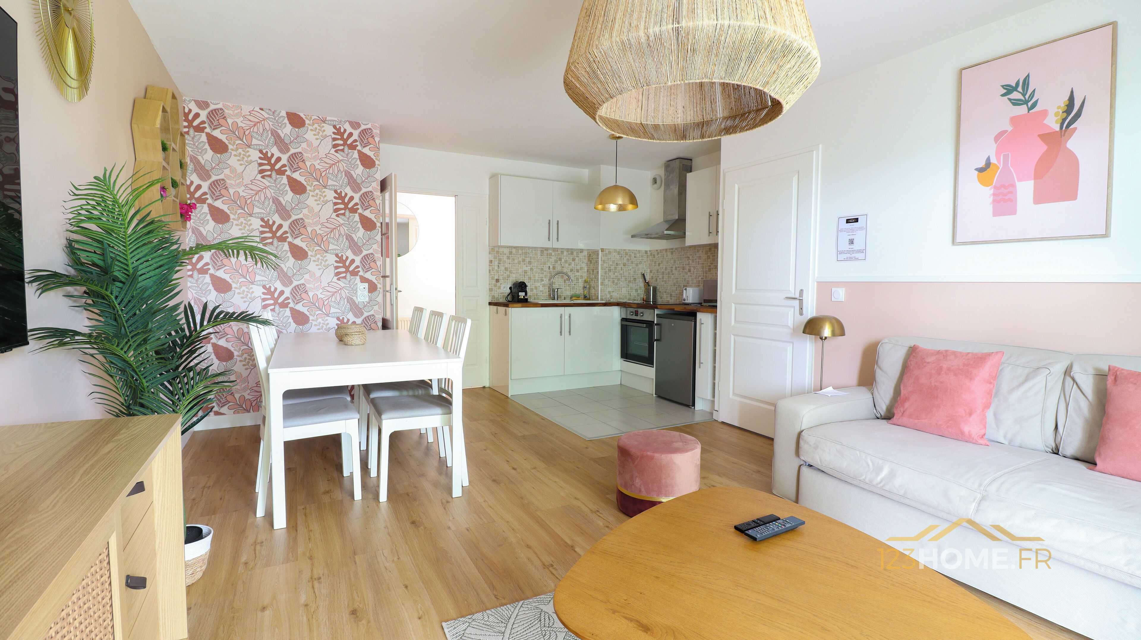 A modern living room with a white sofa, a wooden coffee table, and a dining area with a white table and chairs.