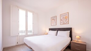 Quarto com uma cama grande, duas mesas de cabeceira e duas obras de arte na parede.
