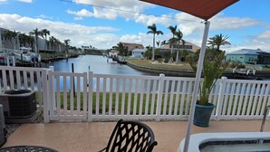 A pool area with a white fence, a pool, and a view of a canal with boats. - Cozy 2-bedroom condo with WiFi, AC in charming Punta Gorda (Punta Gorda)