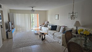 A spacious living room with a sofa, coffee table, and a dining area with a table and chairs. - Cozy 2-bedroom condo with WiFi, AC in charming Punta Gorda (Punta Gorda)