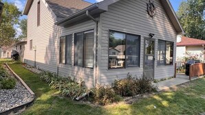 Une maison de plain-pied avec un toit à pignon, de grandes fenêtres et une cheminée bien visible.