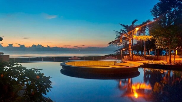 A serene infinity pool with a view of the ocean at dusk. - Timurbay Residence Resort Style (Kuantan)