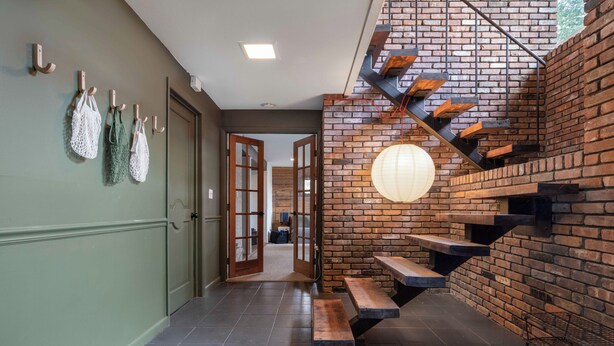 A staircase with wooden steps and a brick wall, leading to an upper level. - Contemporary Hudson Valley home (Staatsburg)