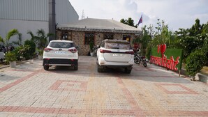 Zwei weiße Autos vor einem Gebäude mit einem Schild, auf dem steht: 'I love Bangladesh'.