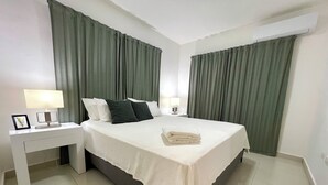 Ein Hotelzimmer mit einem Bett, zwei Nachttischen mit Lampen, einem Schreibtisch und einem schwarzen Teppich.