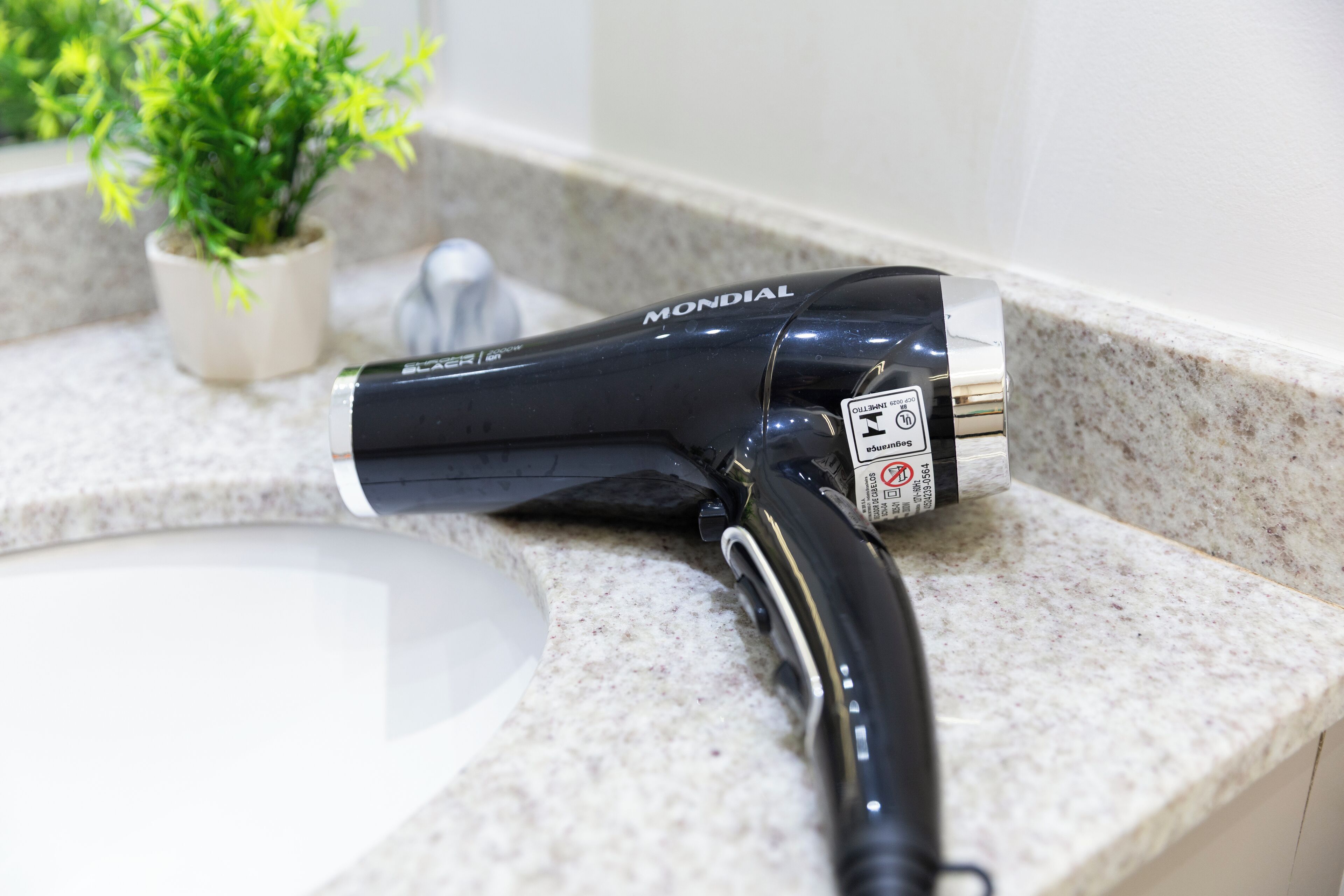 A hair dryer on a bathroom countertop.