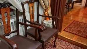A room with a wooden chair, a patterned rug, and a dining area with chairs and a table. - Ρετιρέ μεγάλο 3 δωμάτια.καθιστικό με βεράντα αγ. Κωσταντίνος με θέα το Πήλιο (Volos)