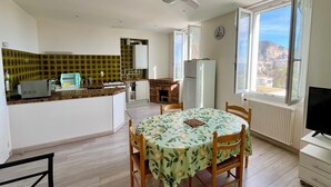 A compact kitchen with a dining area, a ceiling fan, a refrigerator, and a view of the outside through a window. - Magnificent 2p apartment in a villa with sea view, terrace & private parking. (Beaulieu-sur-Mer)