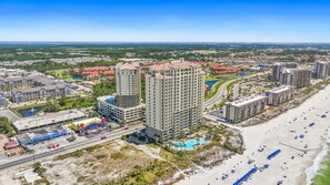A high-rise hotel with multiple floors, a swimming pool, and a beach area with umbrellas. - Grand Panama Resort Penthouse, 2 Pools, 3bd 3ba (Panama City Beach)