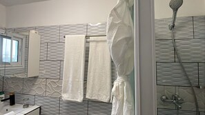 Standaard appartement, uitzicht op tuin | Badkamer | Pantoffels, handdoeken, zeep, shampoo