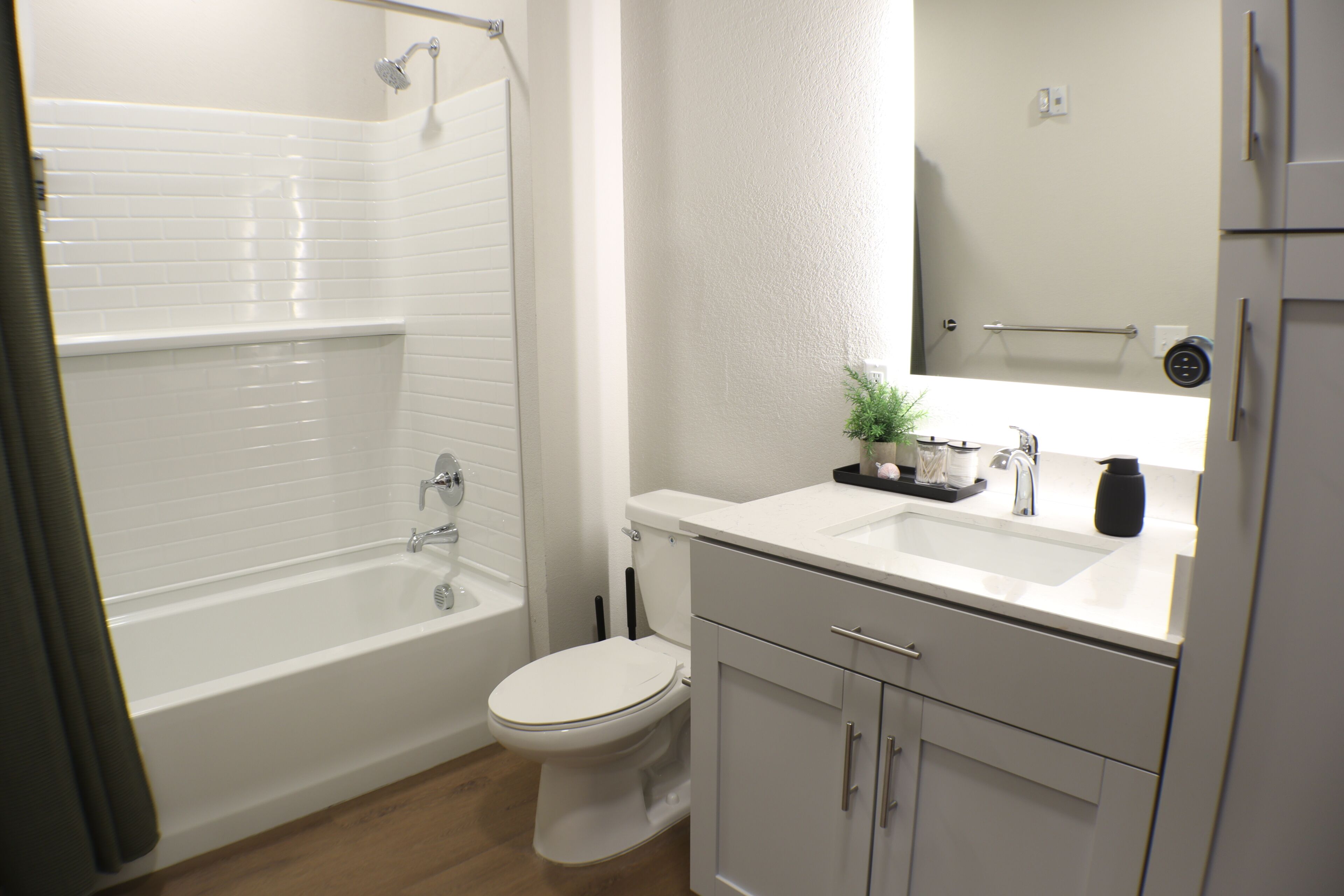 Un baño con bañera, inodoro, lavabo y armarios.