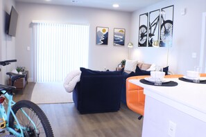 Ein Wohnzimmer mit einer Couch, einem Couchtisch und einem Fahrrad im Vordergrund.