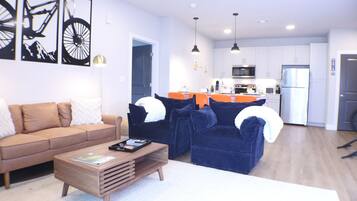 A modern living room with a brown sofa, a blue sofa, and a wooden coffee table.